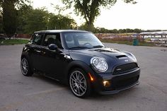 a small black car parked in a parking lot