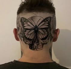 a man with a butterfly and skull tattoo on his head is looking at the camera