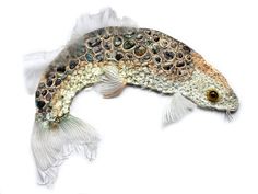 a fish that is laying down on a white surface with its head turned to the side