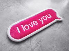 a pink towel with the words i love you on it sitting on top of a table