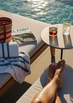 a person laying on top of a chair next to a pool