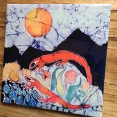 a painting on a wooden table with a red lizard and orange moon in the background