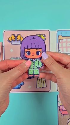 someone holding up a paper cut out of a doll