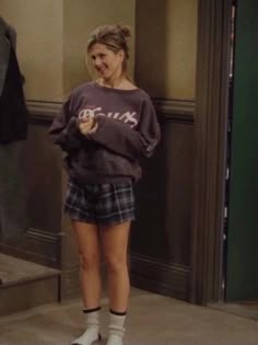 a woman standing in front of an open door with her hand on her hip and looking at the camera