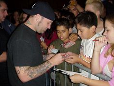 a man signing autographs for children at an event