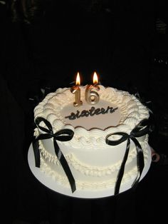 a birthday cake with two lit candles on it