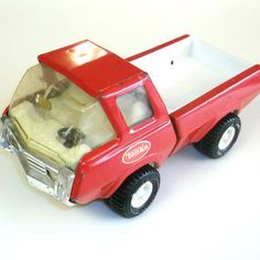 a red toy truck is shown on a white surface