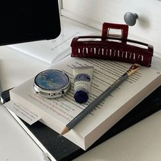 an open book sitting on top of a desk next to a pen and inkwell