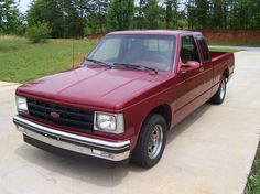 a red pick up truck parked in a driveway