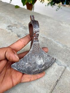 a person holding an old metal object in their hand