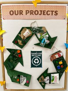 an art project is displayed in front of a white board with green and yellow decorations