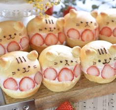 there are many cat shaped pastries with strawberries on them