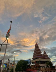 the sky is very cloudy and there are many buildings in the city with flags on them