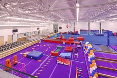 an indoor trampoline gym with purple and orange mats
