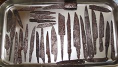 many knives are in a metal tray on the table