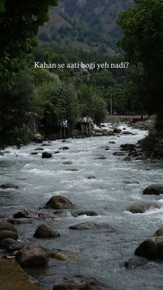 a river with rocks in the water and trees around it