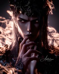 a woman with long hair wearing a crown and holding her hand to her mouth while standing in front of fire