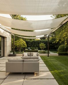 an outdoor living area with couches and tables