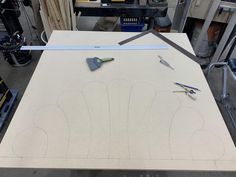 some tools are laying on top of a piece of plywood that has been cut out