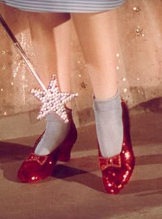 a close up of a person's feet wearing red shoes with sequins