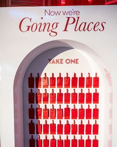 there is a sign that says going places with red bags on the wall behind it