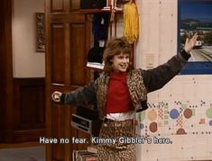 a woman standing in front of a wall holding her arms up