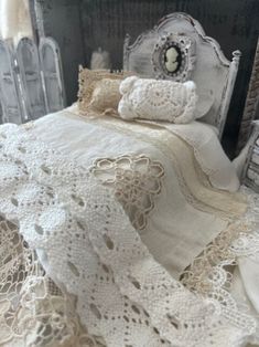 an old fashioned bed with white crocheted bedspread and pillows