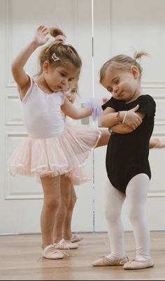 two young ballerinas are practicing their moves