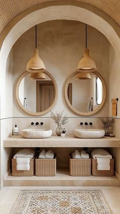 two round mirrors are hanging above the sinks in this bathroom, with wicker baskets underneath them