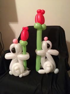 two inflatable balloons sitting on top of a black chair next to each other