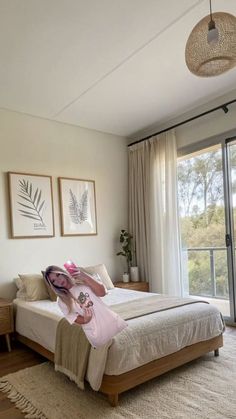 a bedroom with a bed, rugs and pictures on the wall above it in front of a sliding glass door