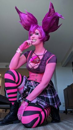 a woman with purple hair sitting on the floor