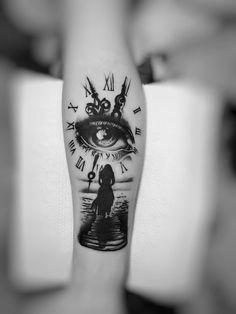 a woman's arm with a clock and an eye tattoo on her left forearm