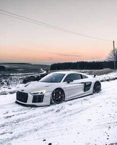 a white sports car parked in the snow