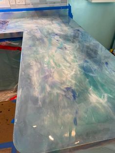 the counter top is being painted with blue and white paint, as well as other materials