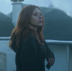 a woman standing on top of a boat in the ocean looking off into the distance