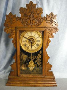 an ornate wooden clock on display against a blue background