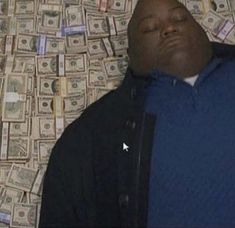 a man laying on top of a bed covered in money
