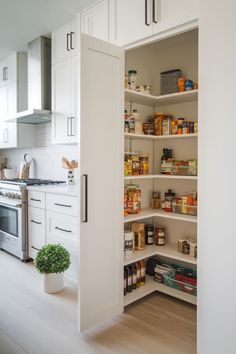 an open pantry door in a white kitchen