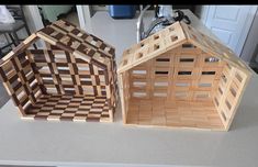 two wooden houses sitting on top of a counter next to each other in front of a sink