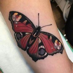 a colorful butterfly tattoo on the arm