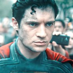 a close up of a person holding a cell phone in front of a group of people