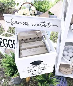 an egg carton with eggs in it sitting on the ground next to some plants