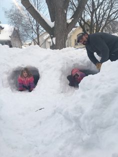 a man and two children playing in the snow