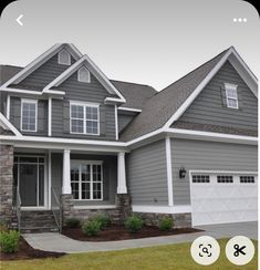 a gray house with white trim and two car garage doors on the front door is shown