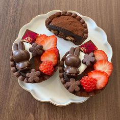 two desserts on a plate with strawberries, chocolate bunny and heart shaped cookies