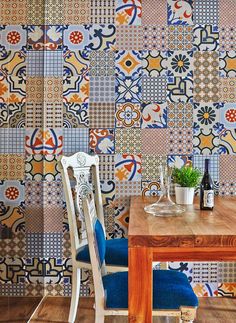 a wooden table sitting in front of a wall covered in colorful tile tiles on it