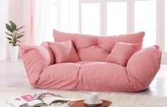 a pink bean bag chair sitting on top of a white rug