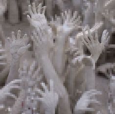 several white hands reaching up into the air