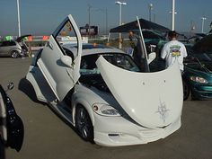 a white car with its doors open in a parking lot